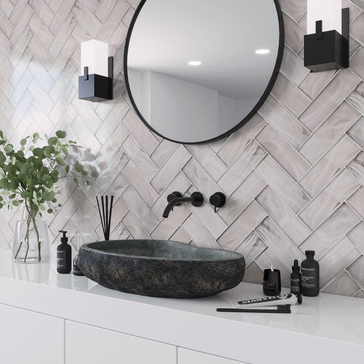 Bathroom vanity backsplash with Sea Glass Platinum subway tiles in a herringbone layout