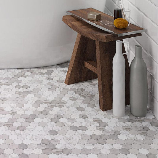 A Wooden Bench and Ceramic Jugs Stand on the Calacatta Gold Hexagon Tile Polished Floor