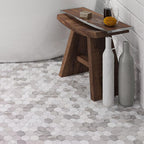 A Wooden Bench and Ceramic Jugs Stand on the Calacatta Gold Hexagon Tile Polished Floor