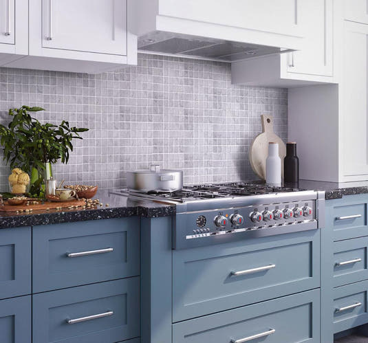 Blue and white kitchen with square white carrara mosaic tile backsplash
