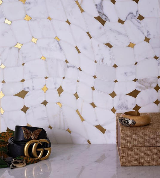 calacatta golden marble and brass tile backsplash