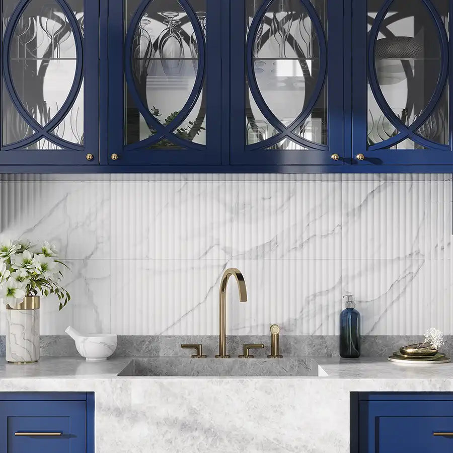 Fluted marble-look backsplash tile paired with bold blue cabinets and a stone farm sink