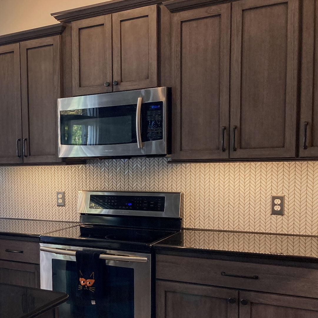 Dark wood and stainless steel appliances with White Leaf Recycled Glass Mosaic Tile backsplash