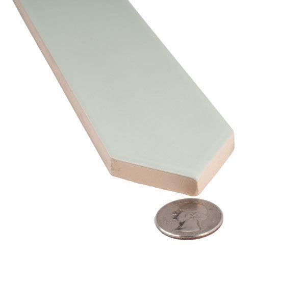 Mint green ceramic tile close-up with coin