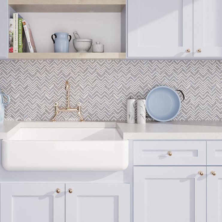Blue and white farmhouse kitchen with chevron marble tiles