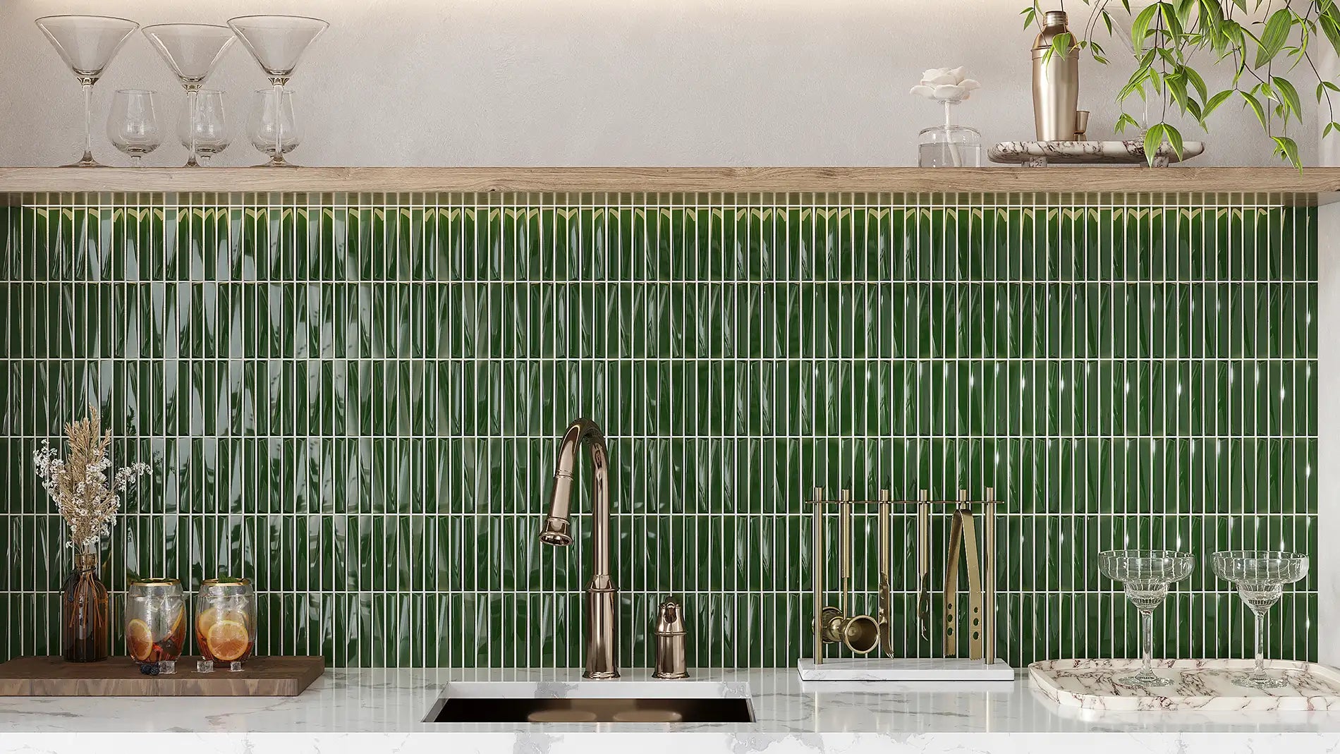A kitchen backsplash featuring glossy vertical green glass tiles with white grout lines, installed behind a white marble countertop and a copper-toned faucet.