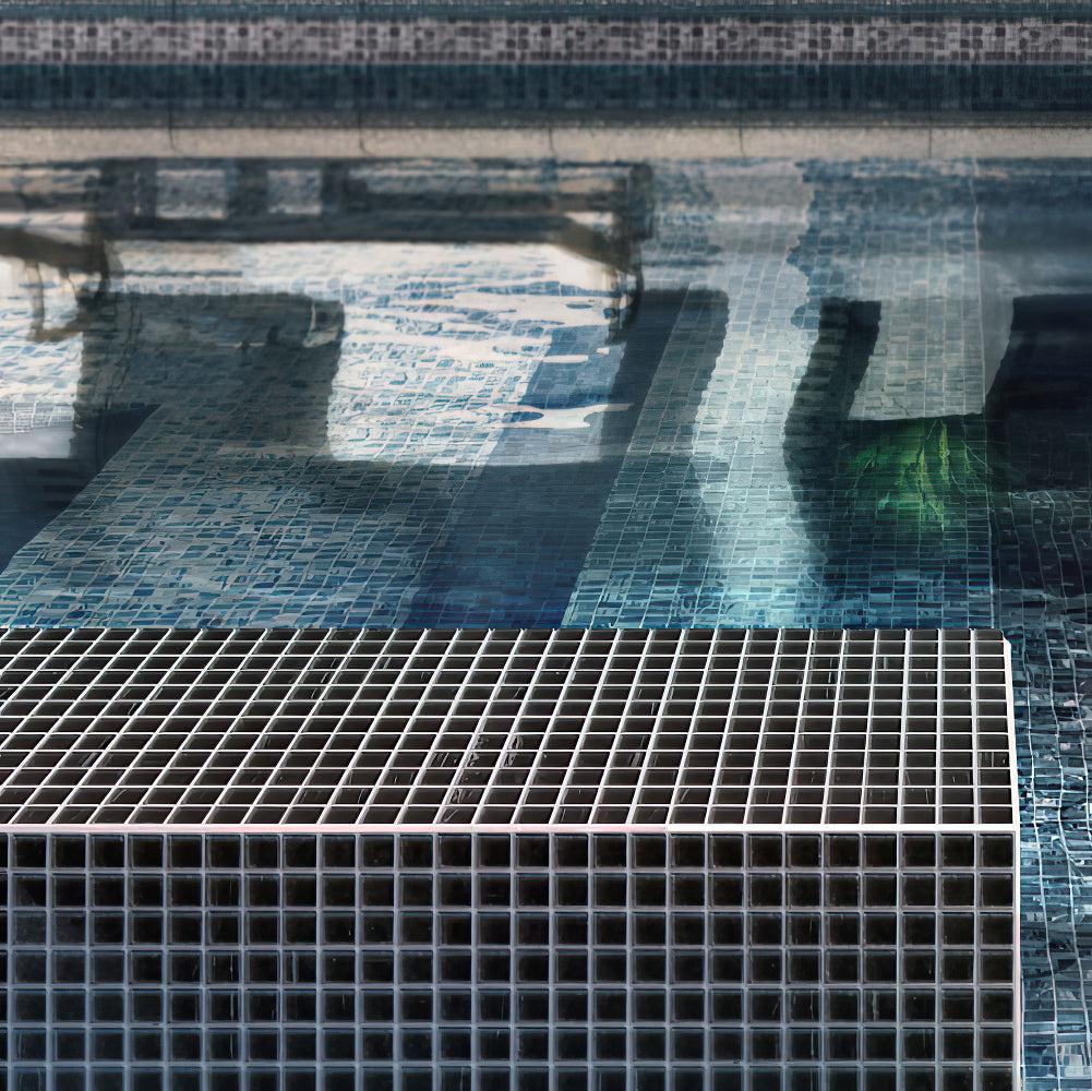Black brushed glass tile swimming pool edge in sunlight