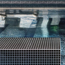 Black brushed glass tile swimming pool edge in sunlight