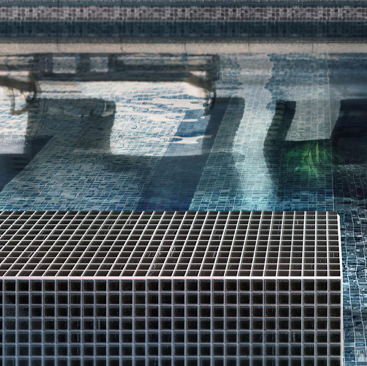 Black brushed glass tile swimming pool edge in sunlight