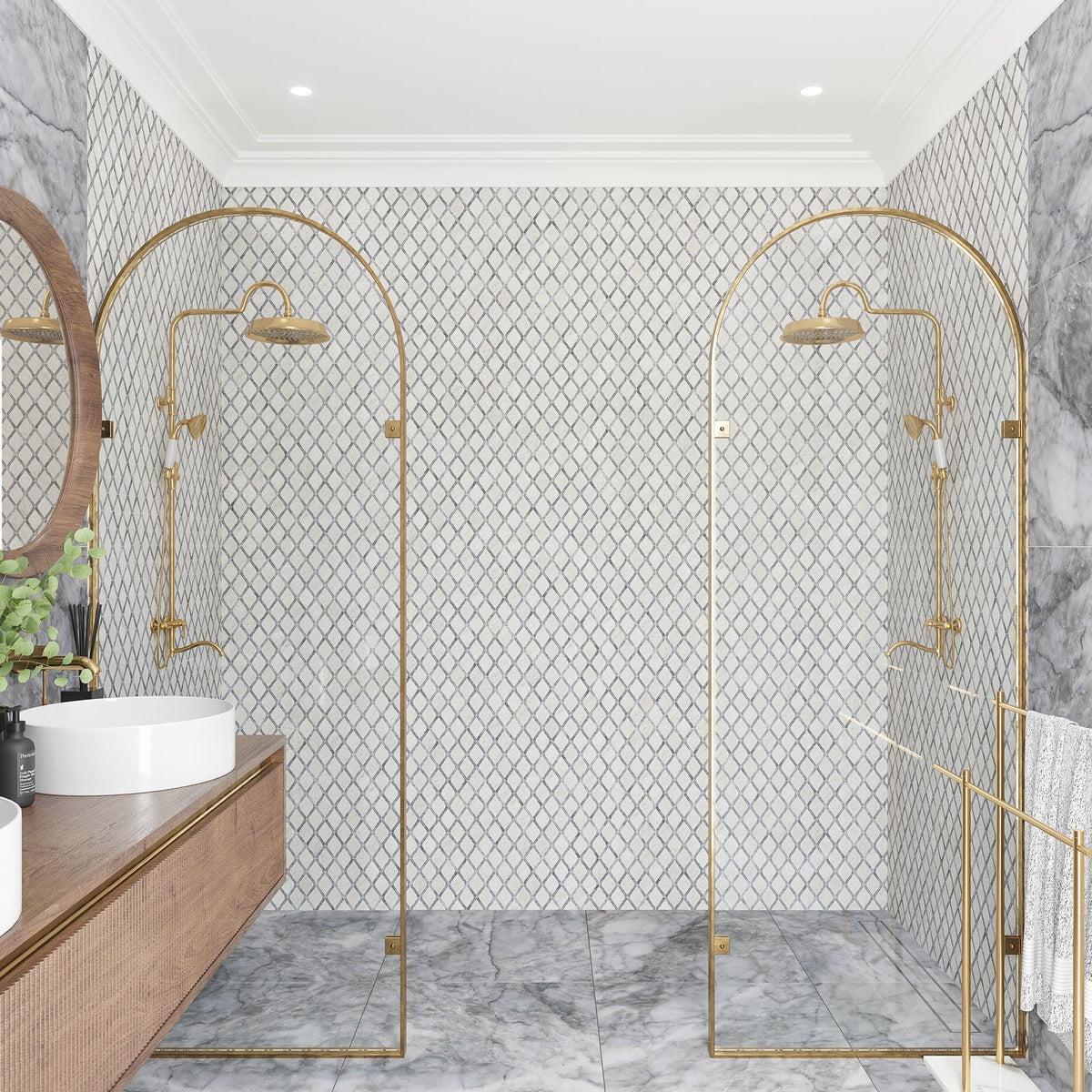 Marble bathroom shower wall with gold fixtures and natural decor