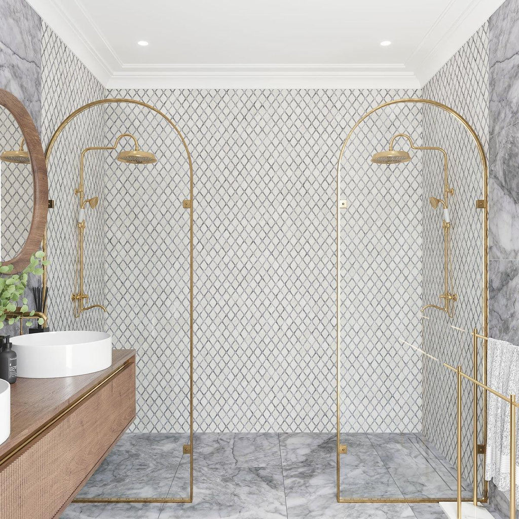 Marble bathroom shower wall with gold fixtures and natural decor