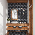 Bathroom with wooden vanity, sink, and decorative mirror against a patterned black wall tile with a matching bathroom floor inset into wood
