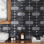 Modern bathroom with geometric black and gray tile backsplash with naturally colored stone accents