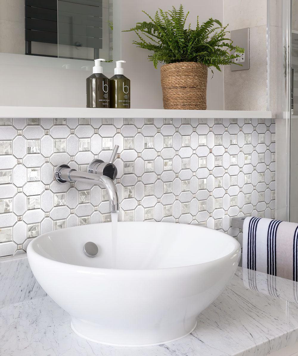 White washbasin in the bathroom against the background of a Geometric Pearl White Thassos Shell Tile backsplash