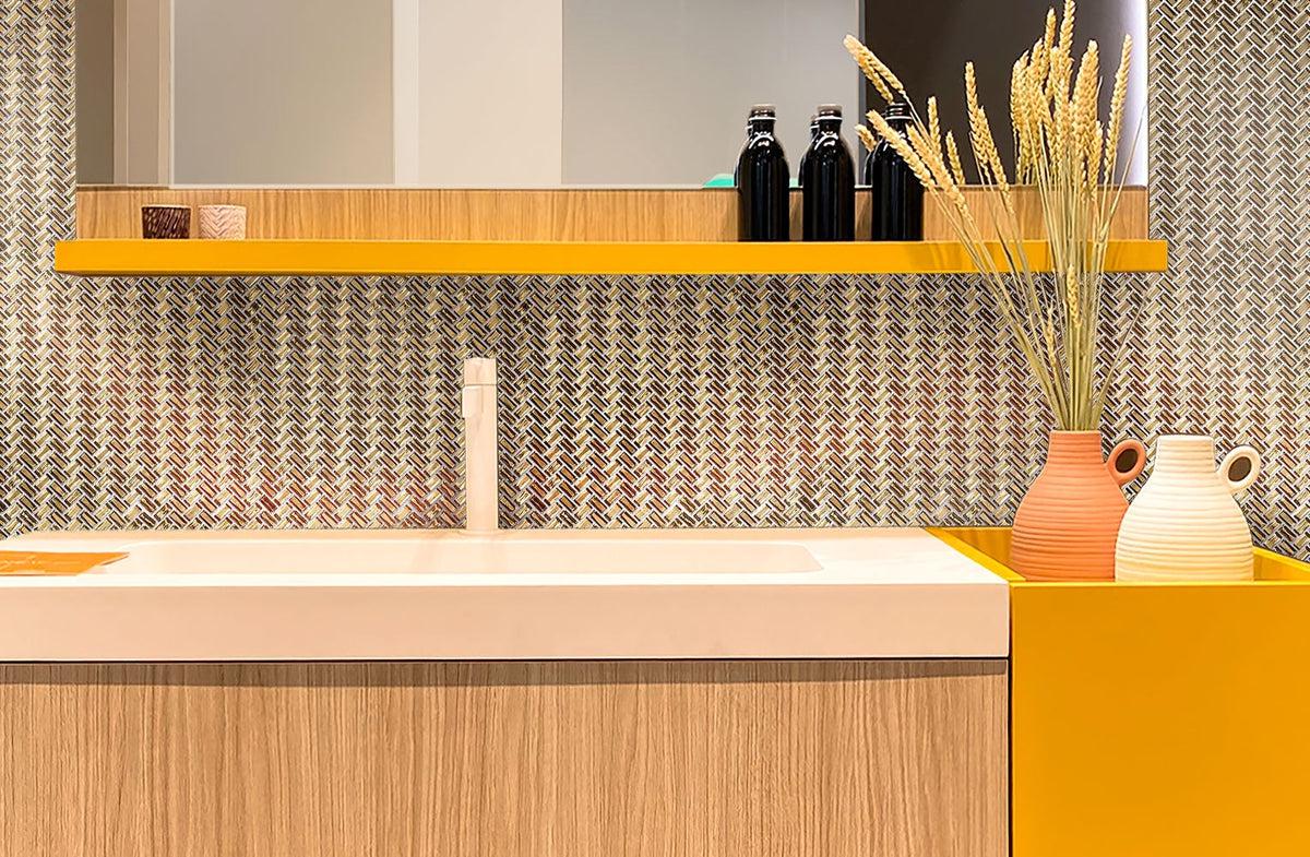 Gold Herringbone Mosaic Tile backsplash in a yellow & wood geometric bathroom