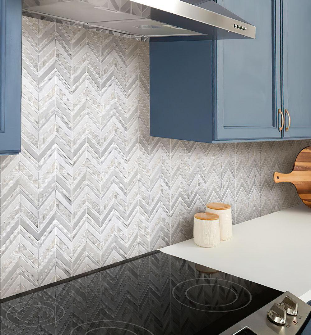 Herringbone Pearl White Thassos Marble and Shell Tile backsplash in kitchen with navy blue cabinets