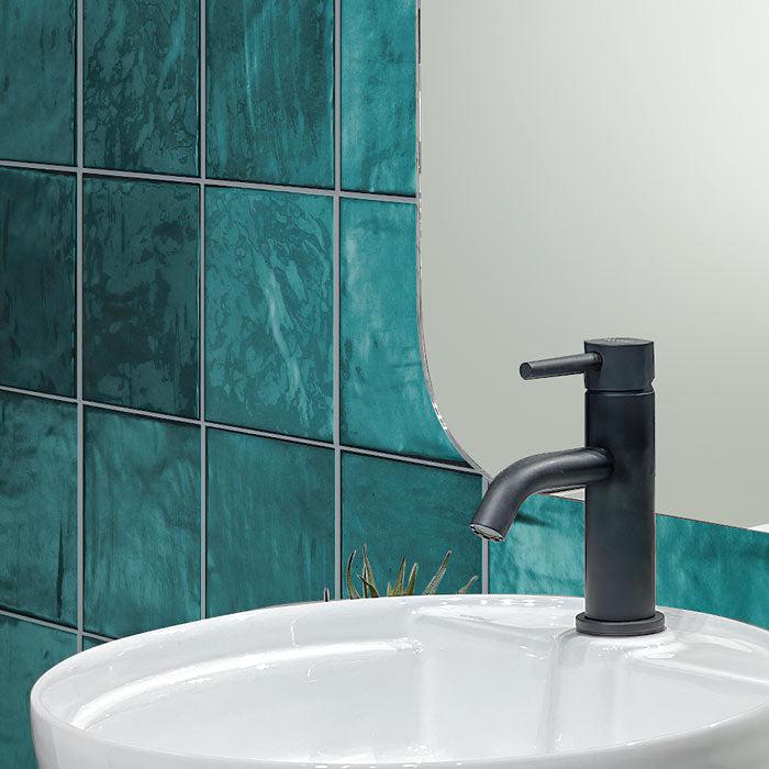 White Ceramic Bathroom Sink with Black Faucet on La Riviera Quetzal Ceramic Tile Backsplash