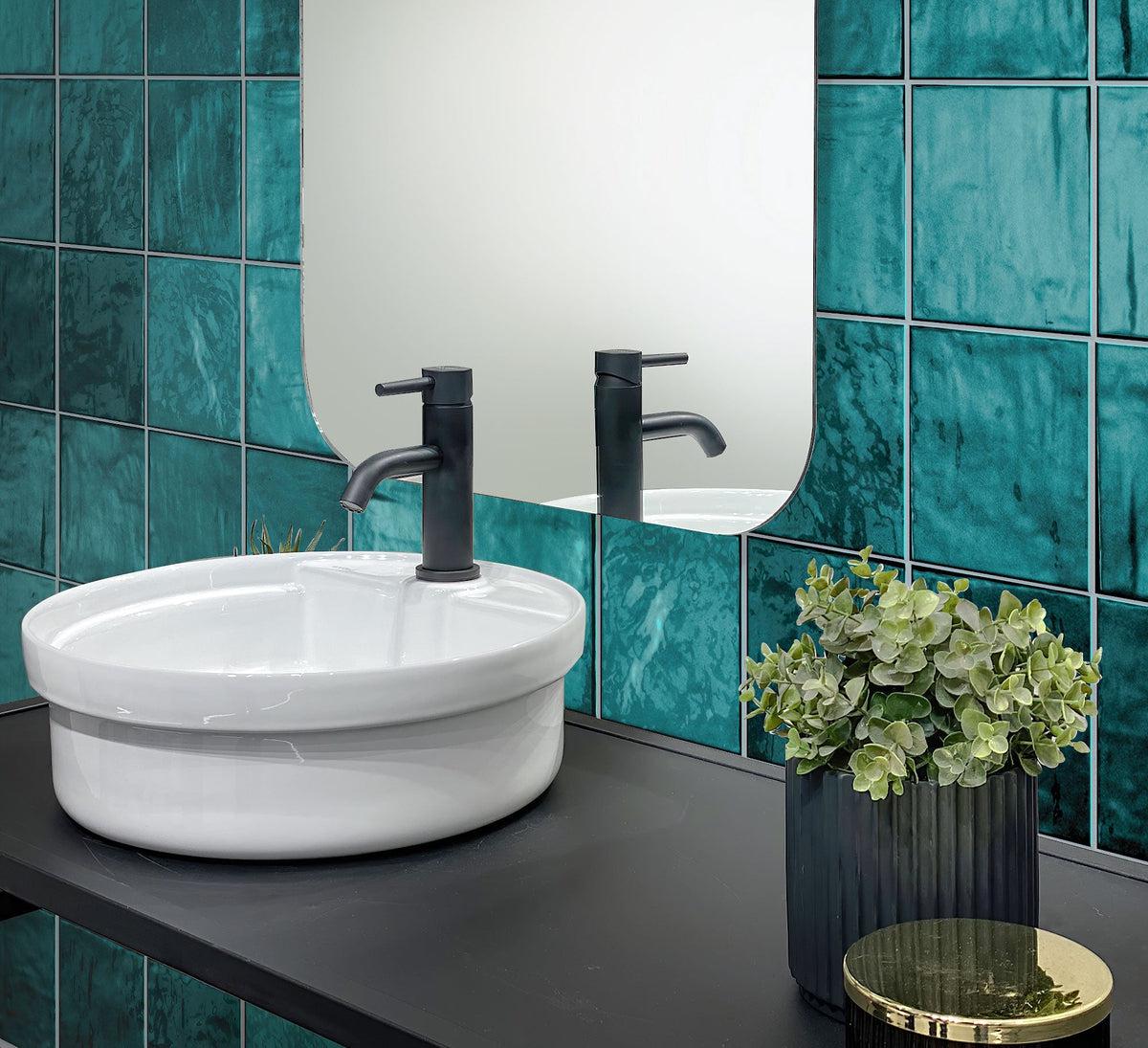 Round White Ceramic Sink with Black Faucet on La Riviera Quetzal Ceramic Tile Wall Background