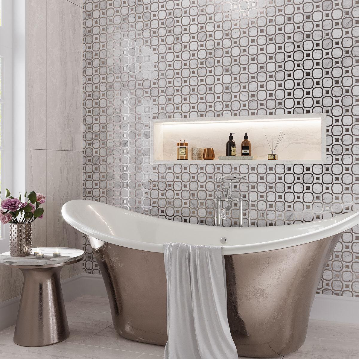 Silver and white bathroom with  glass and marble geometric tiles and a free standing tub
