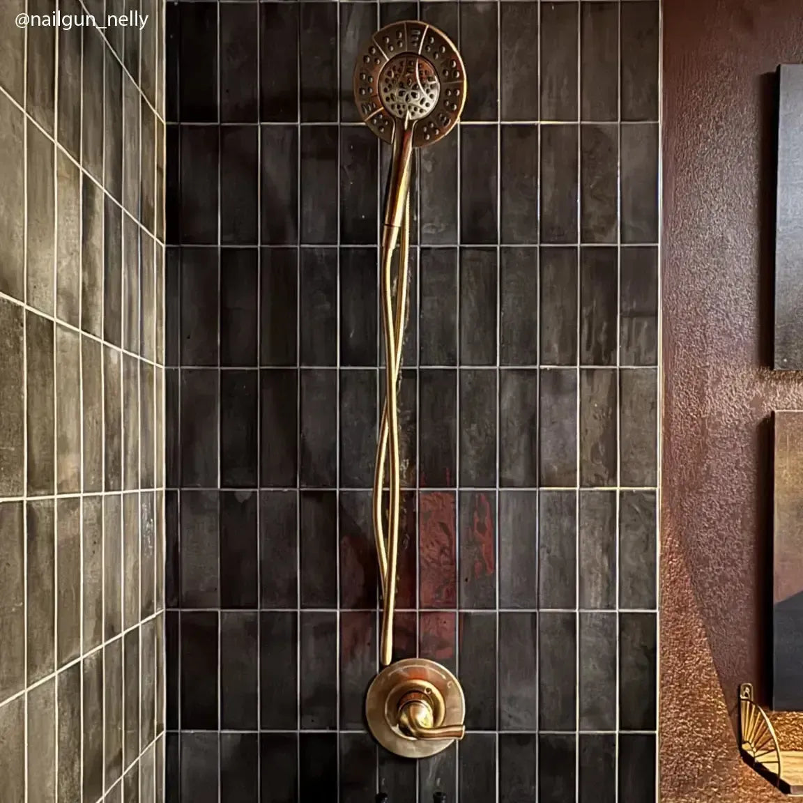 Black shower tile with handmade style and gold fixtures