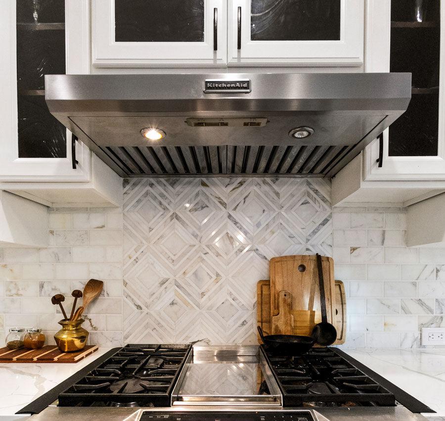 Calacatta Diamond backsplash behind the stove with marble subway tiles