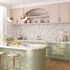 Playful pastel kitchen full of natural light and colorful marble mosaic tile backsplash in an oval pattern