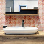 The bathroom walls glow with Peach Sunrise Glass Squares Tile