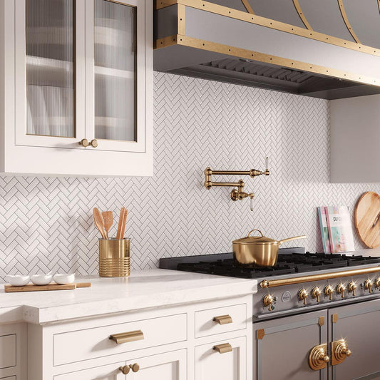 White and Gold Kitchen with marble herringbone backsplash tile behind the stove