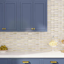 Blue kitchen cabinetry with white and gold glass tile backsplash