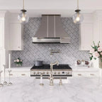 White and silver kitchen with etched marble arabesque backsplash tile and brushed nickel hood range