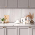 Modern neutral kitchen with white herringbone peel and stick tile backsplash