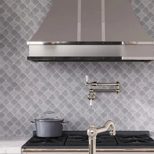 Etched white and silver arabesque tile backsplash